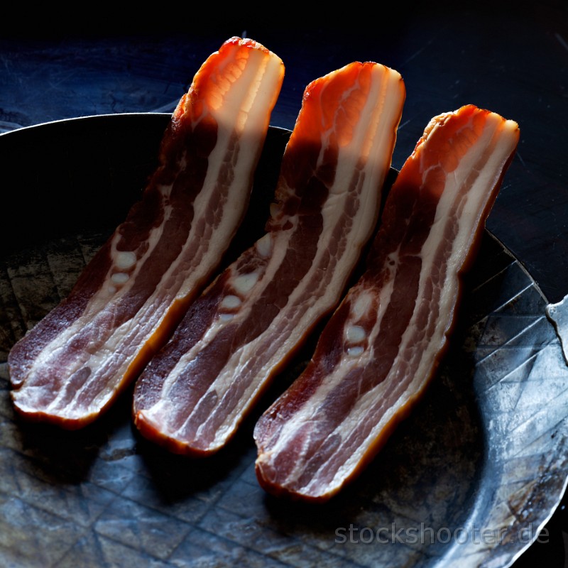 _MG_7000_baconpan_square.jpg - three stripes of bacon in a pan