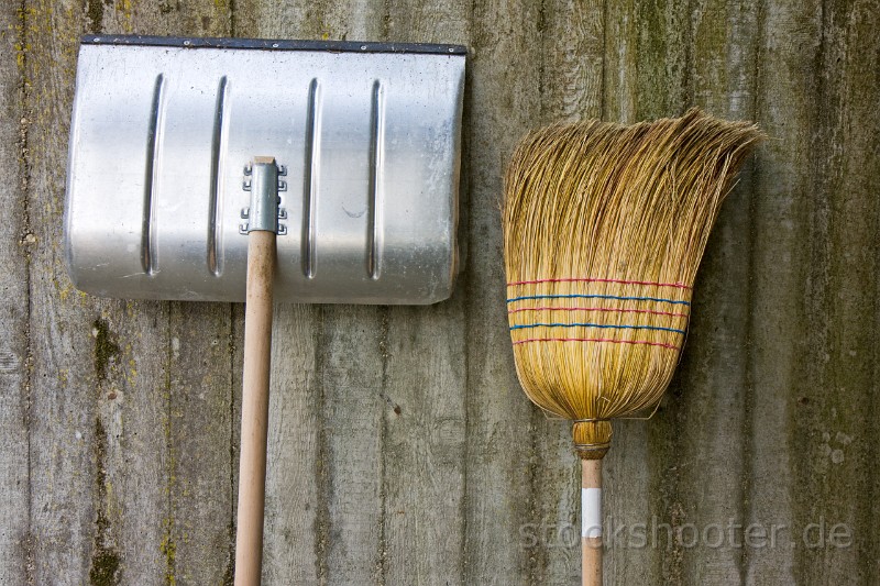 IMG_3488_snowshovel_broom_ala.jpg - three used brooms on a concrete wall