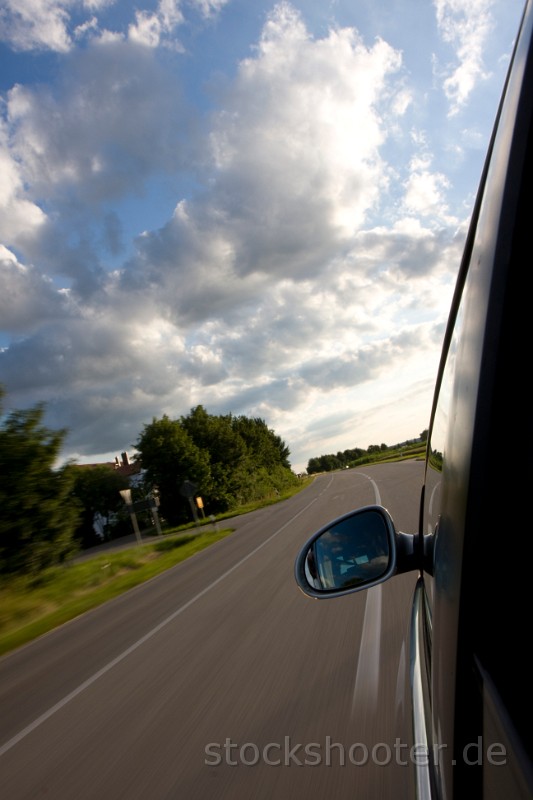mirror7.jpg - detail of a car driving on a country road